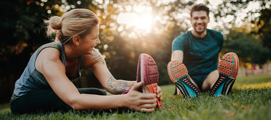 Man and woman stretching in park